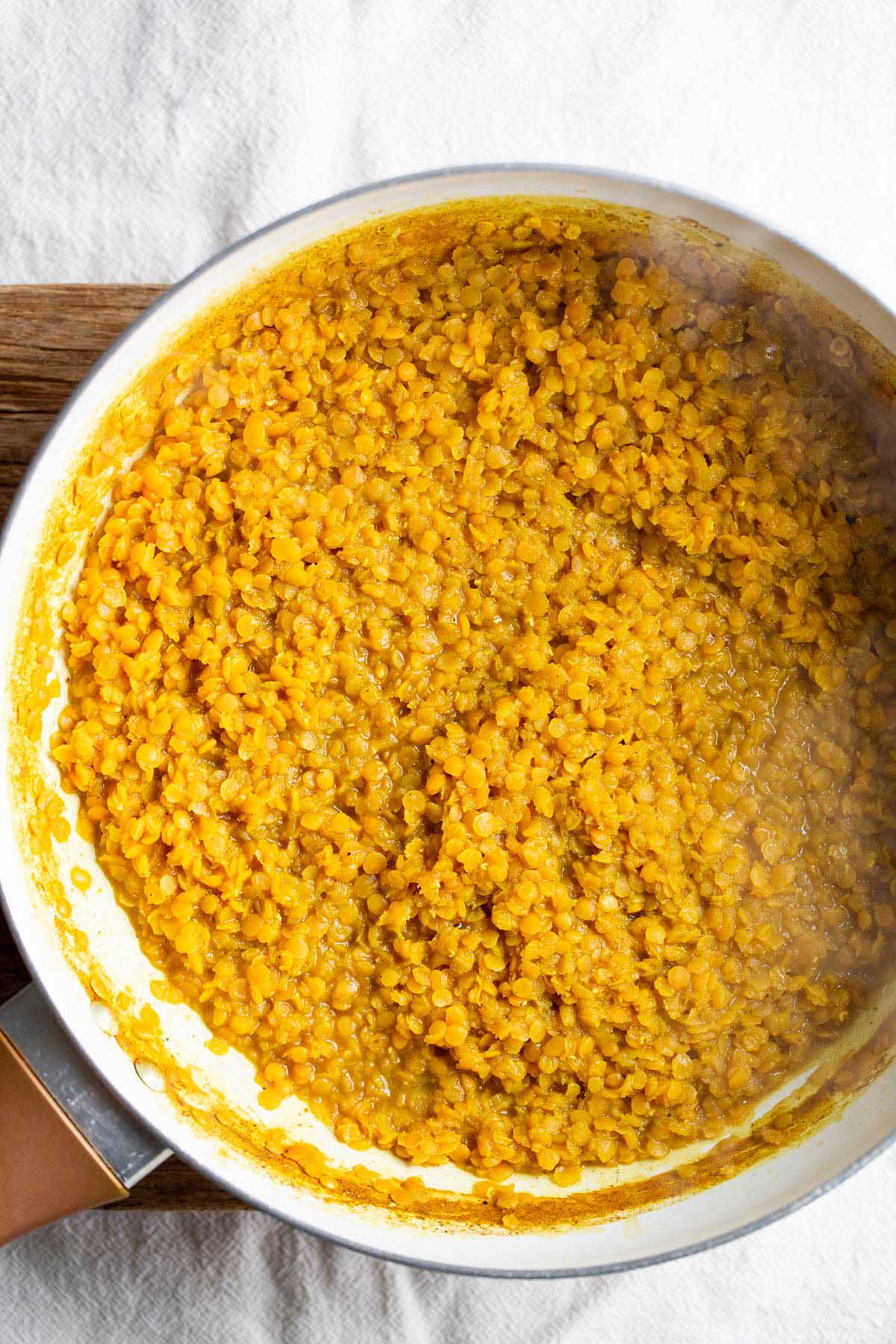 Red lentils cooked in a skillet.