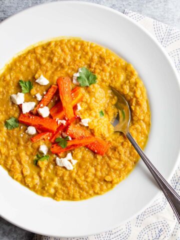 Red lentil dal topped with carrots, cilantro, and feta.