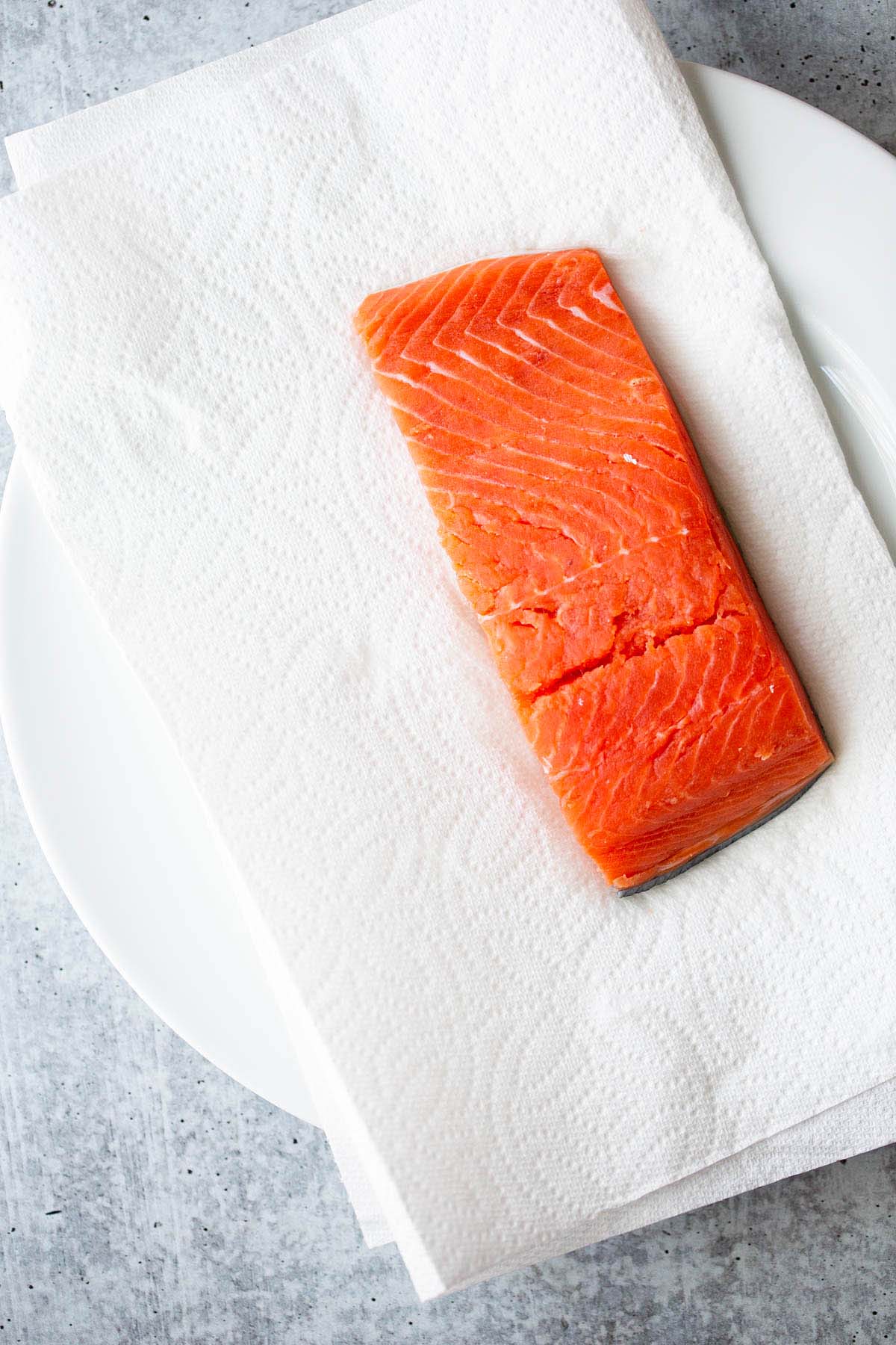 Raw salmon on a white plate.