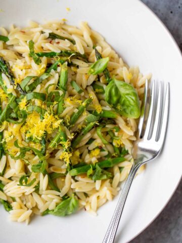 Asparagus and orzo in a bowl up close.