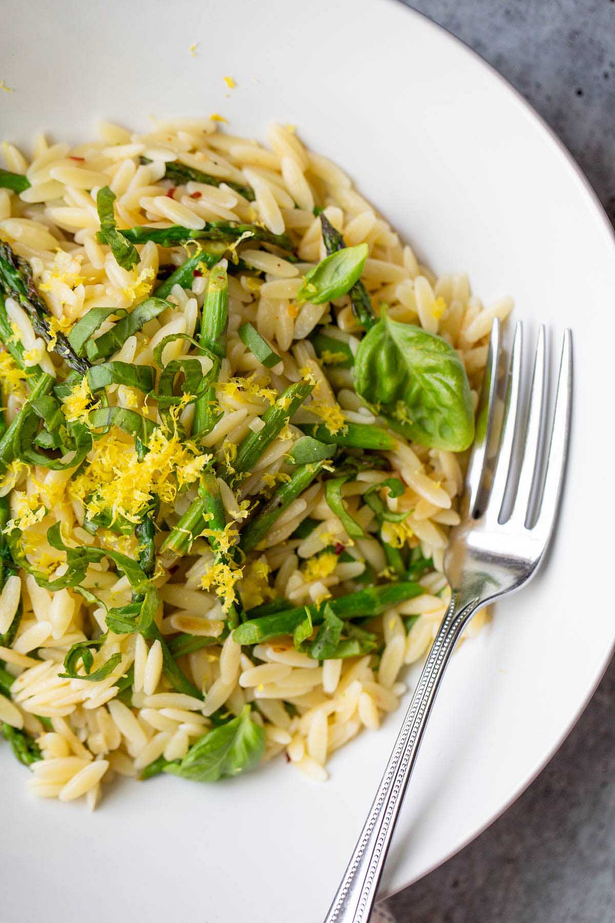 Asparagus and orzo in a bowl up close.