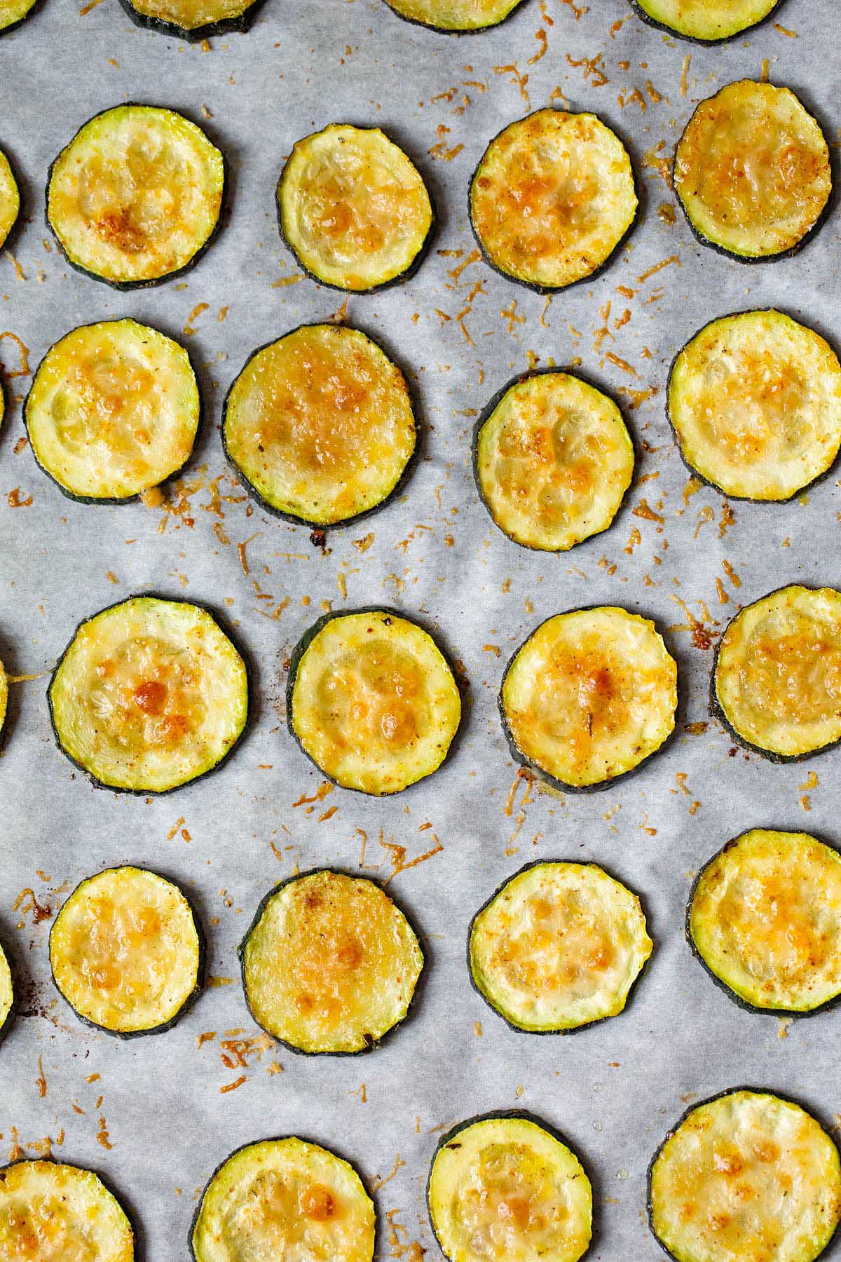 Baked zucchini chips on a baking sheet.