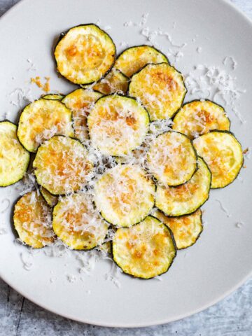 harissa zucchini chips with parmesan on top.