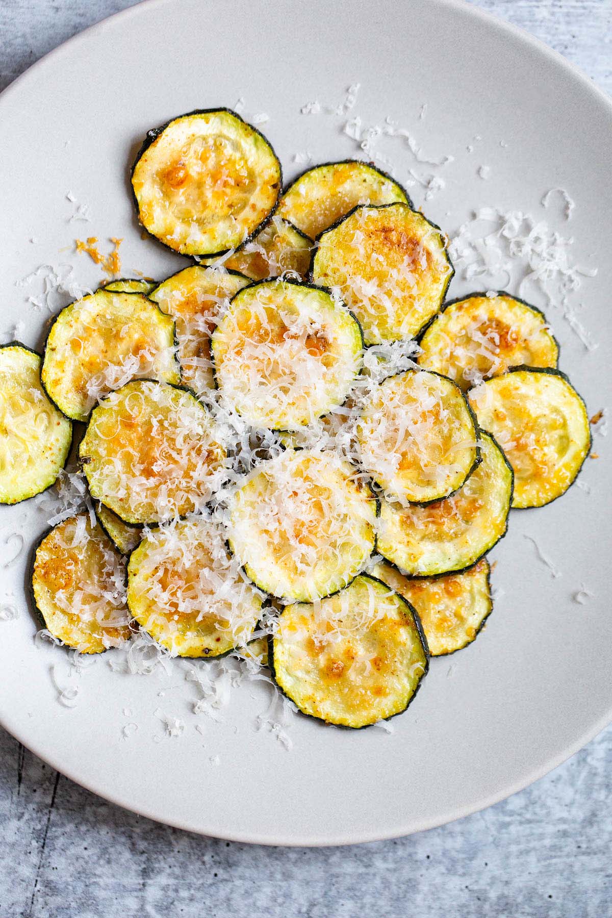 harissa zucchini chips with parmesan on top.