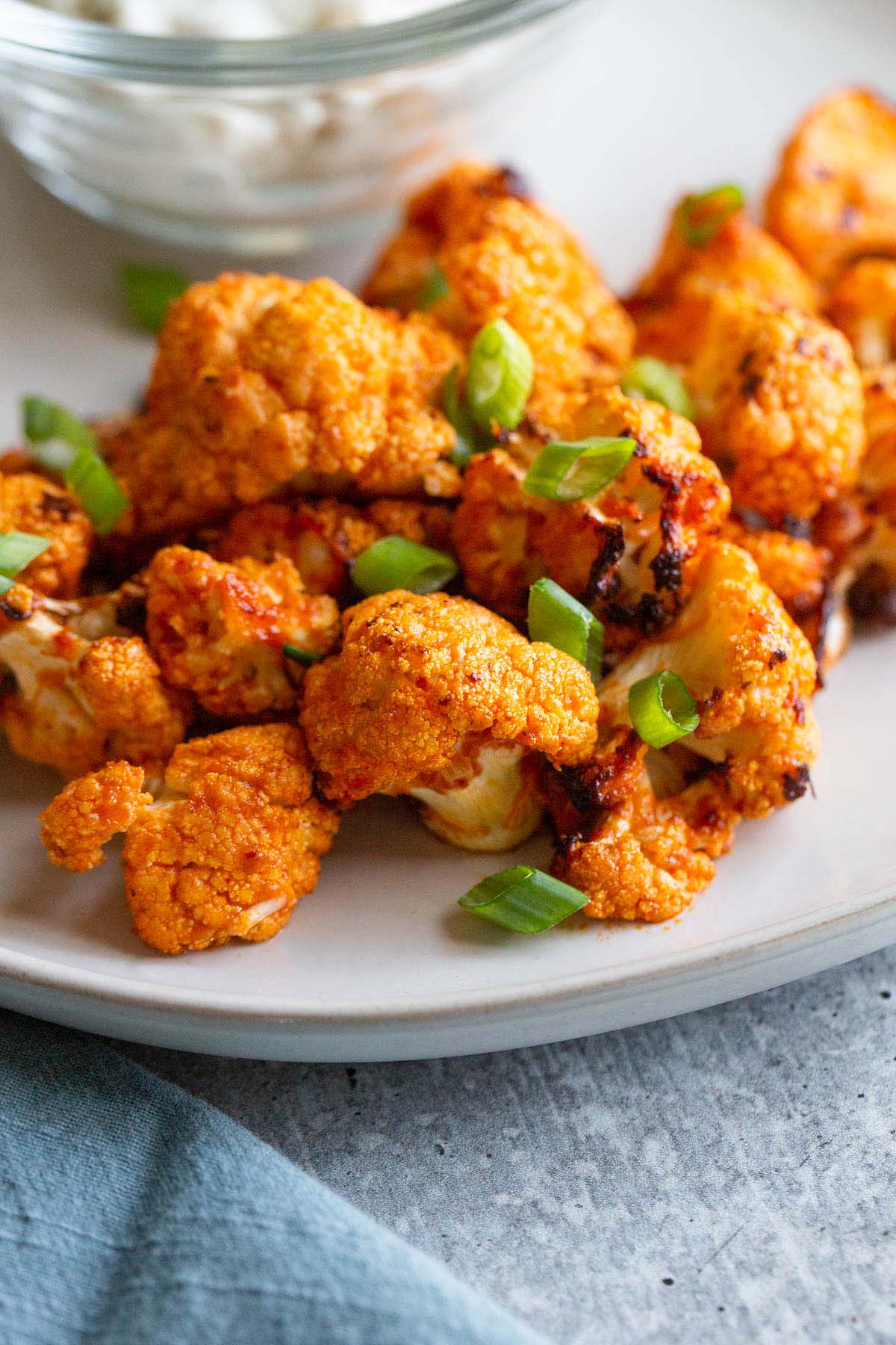 Air fryer buffalo cauliflower with green onions.