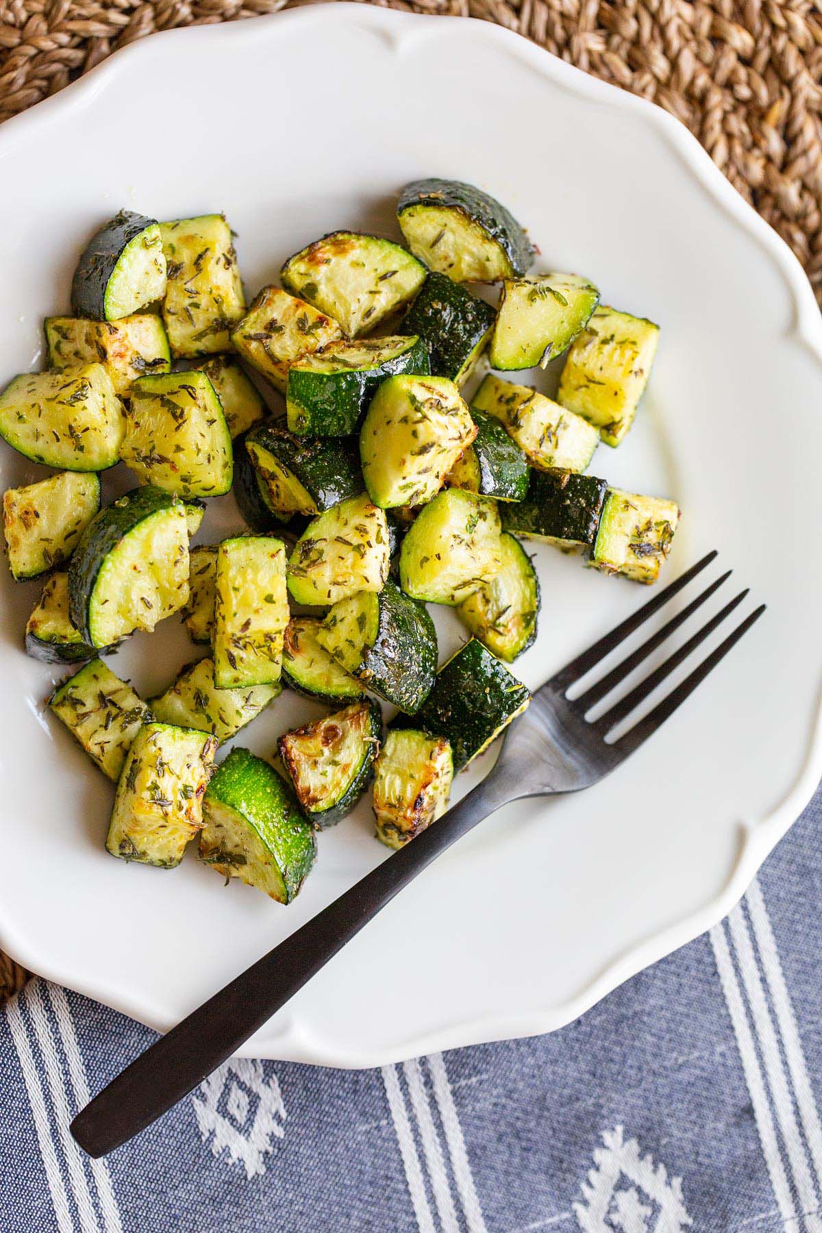 Zucchini on a white plate with a fork.