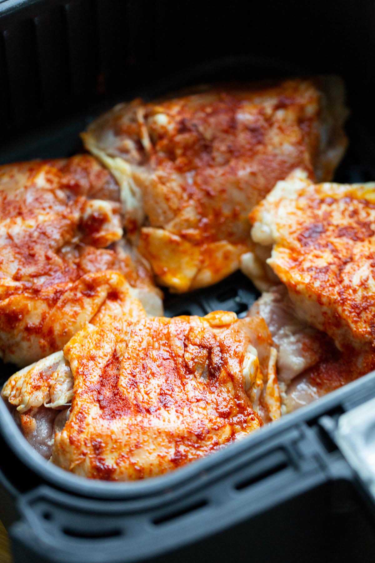 Uncoooked chicken thighs in the air fryer.