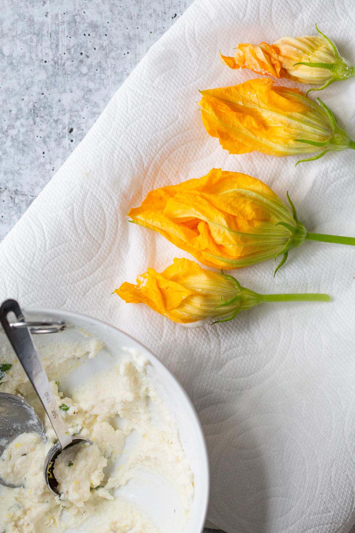 Stuffing zucchini flowers with ricotta.