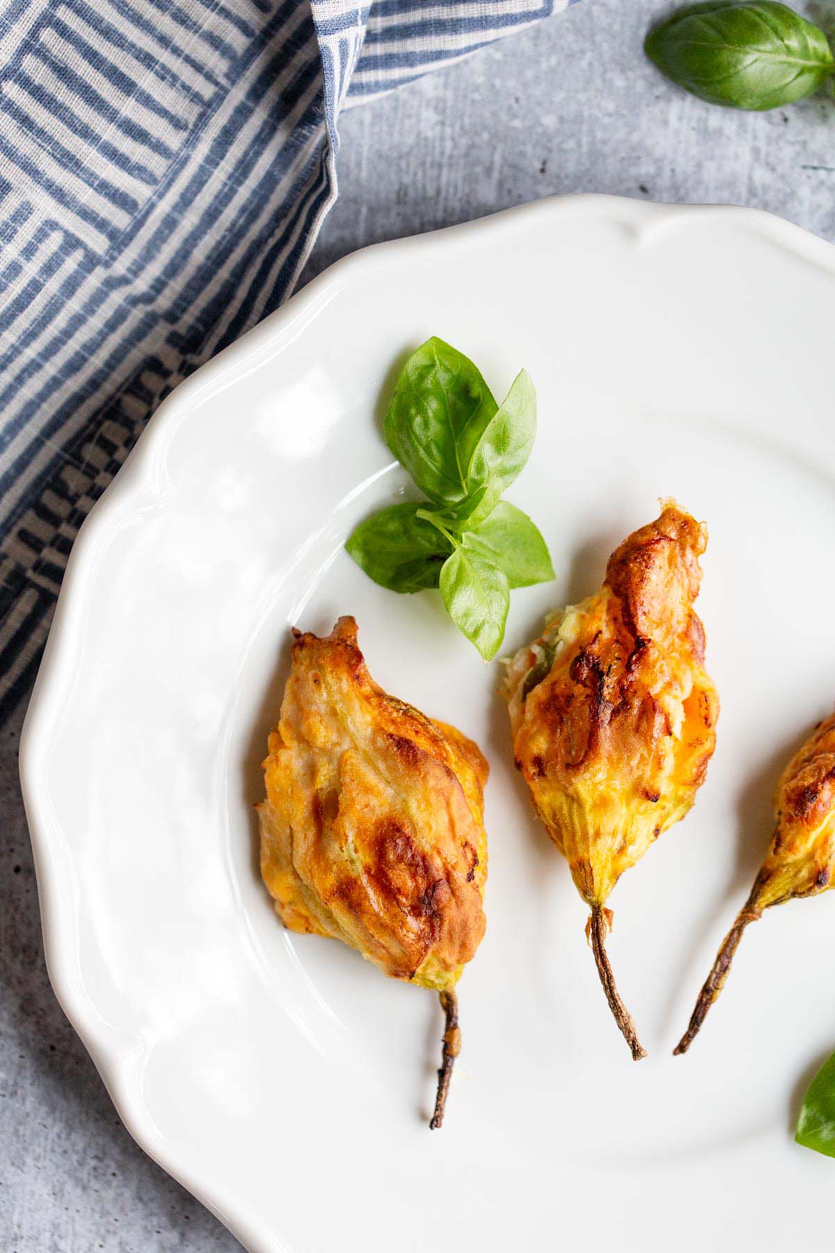 Stuffed Zucchini blossoms on a plate from above.