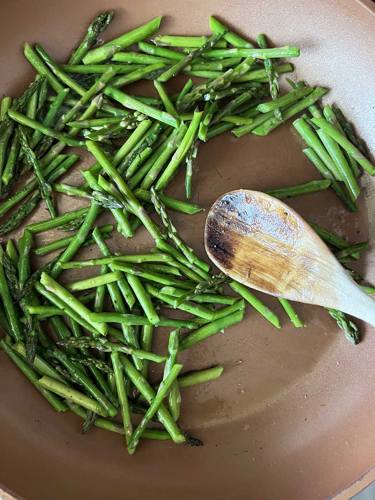 Asparagus cooking in a pan.