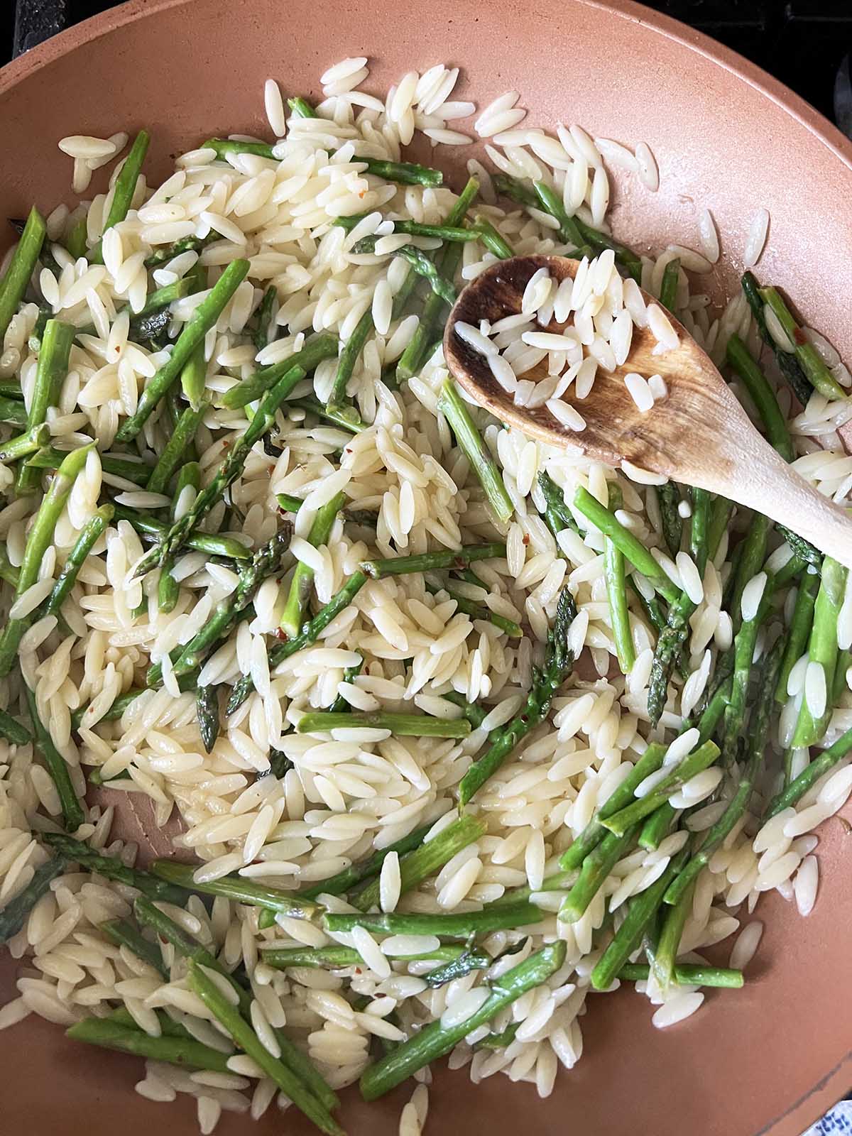 Asparagus and orzo in a pan.