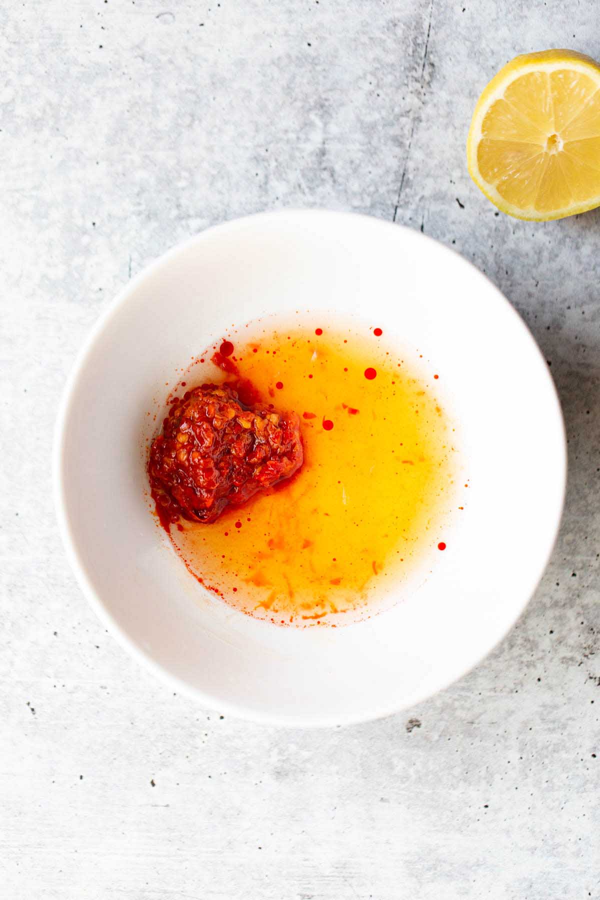 Harissa, lemon juice, and honey in a bowl.