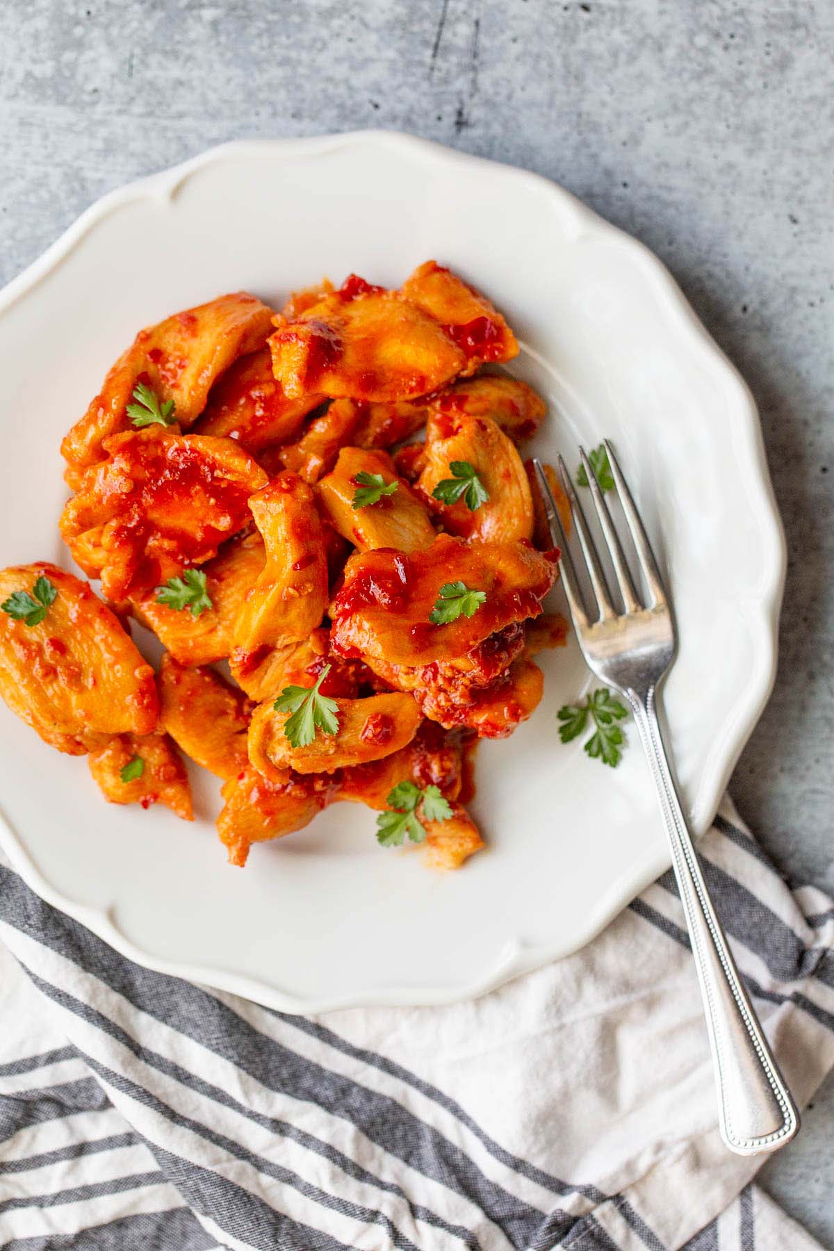 Harissa chicken on a plate with a fork.