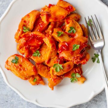 Harissa chicken on a plate with a fork.