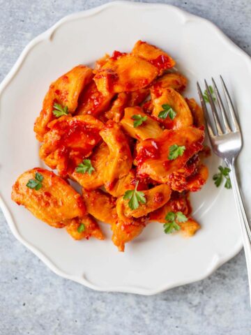 Harissa chicken on a plate with a fork.