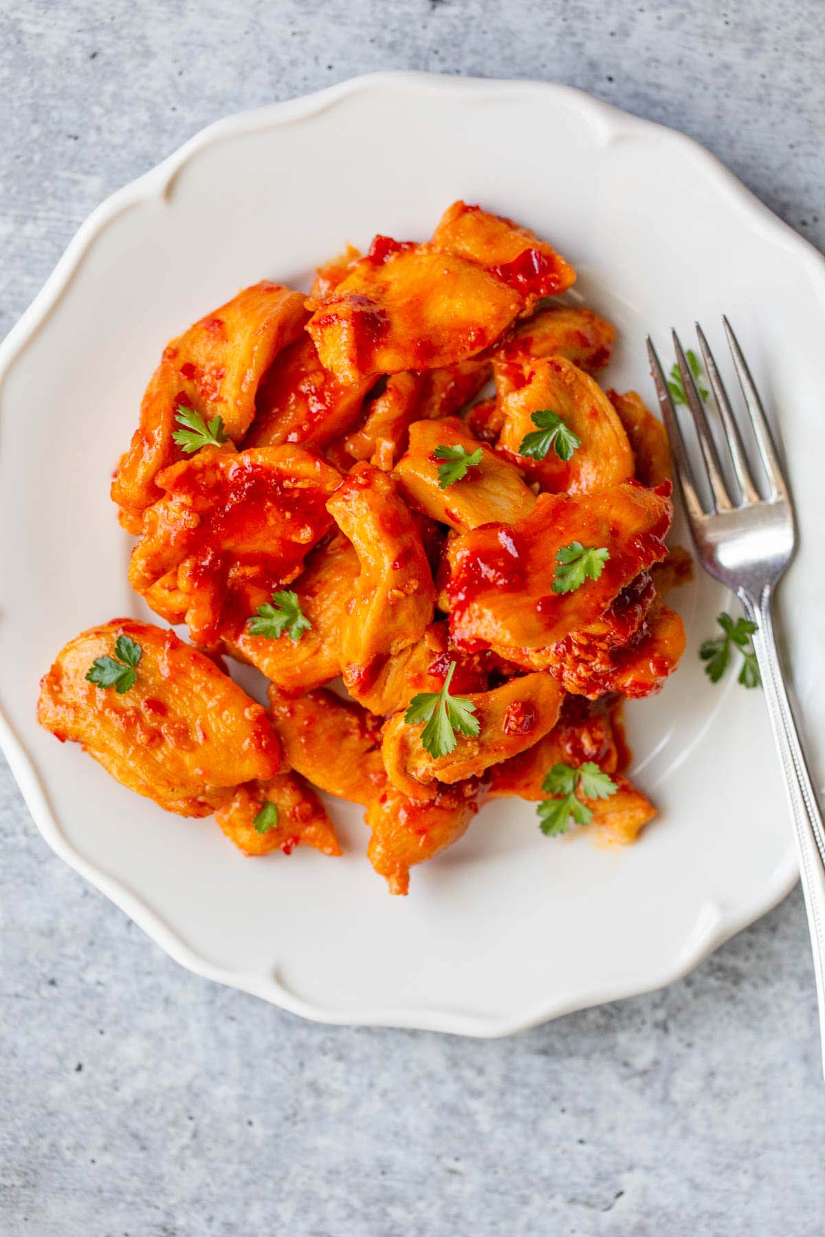 Harissa chicken on a plate with a fork.