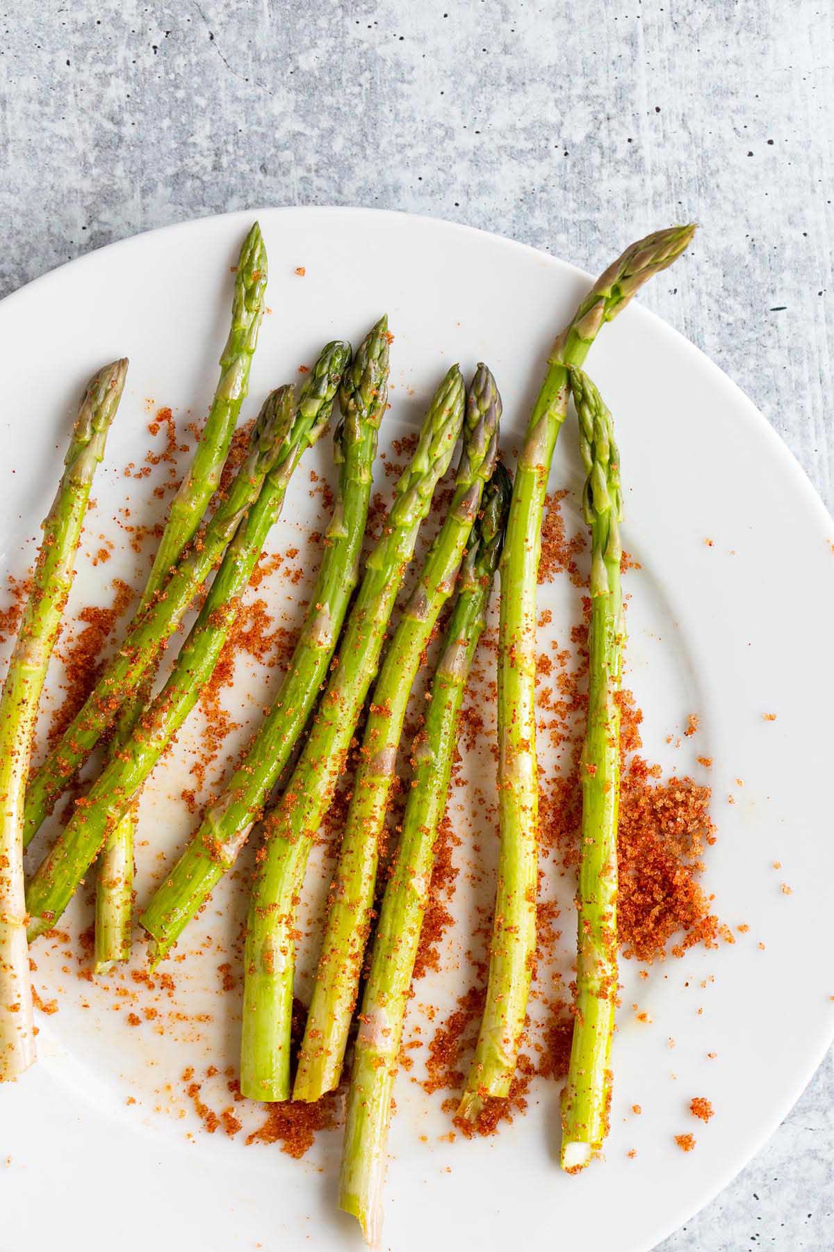 Asparagus on a plate with spices.