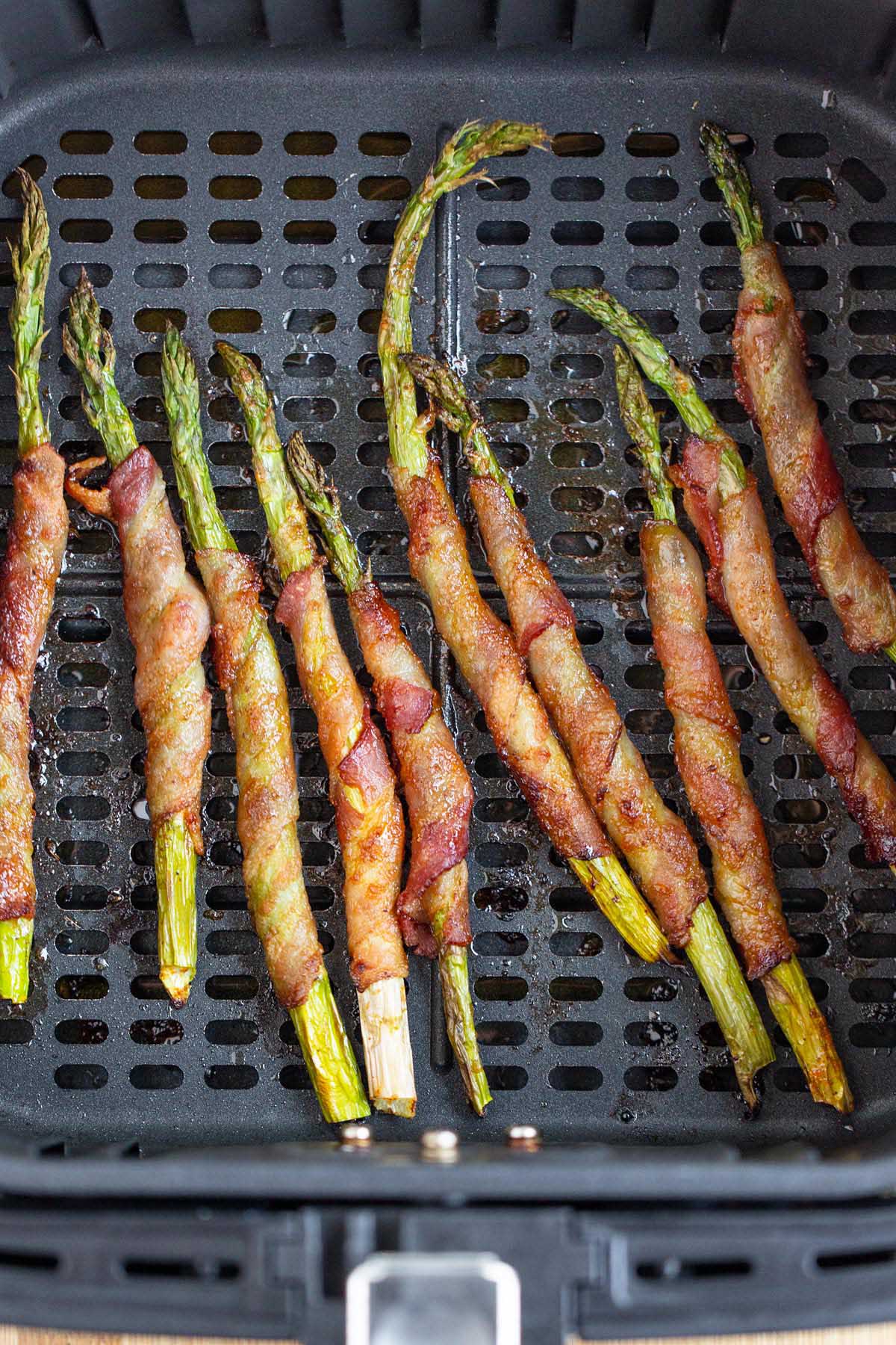 Bacon wrapped asparagus in air fryer basket.