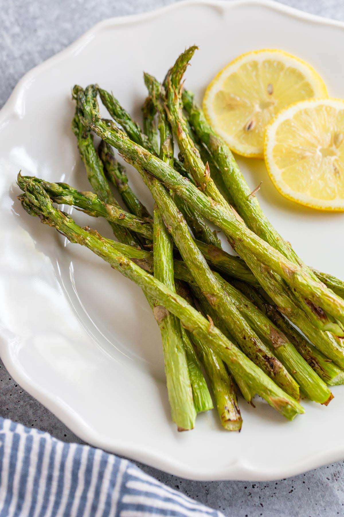 Asparagus on a plate with lemon slices.