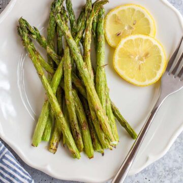 Asparagus on a plate with lemon slices.