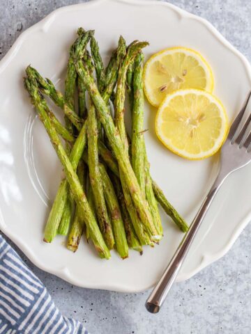 Asparagus on a plate with lemon slices.