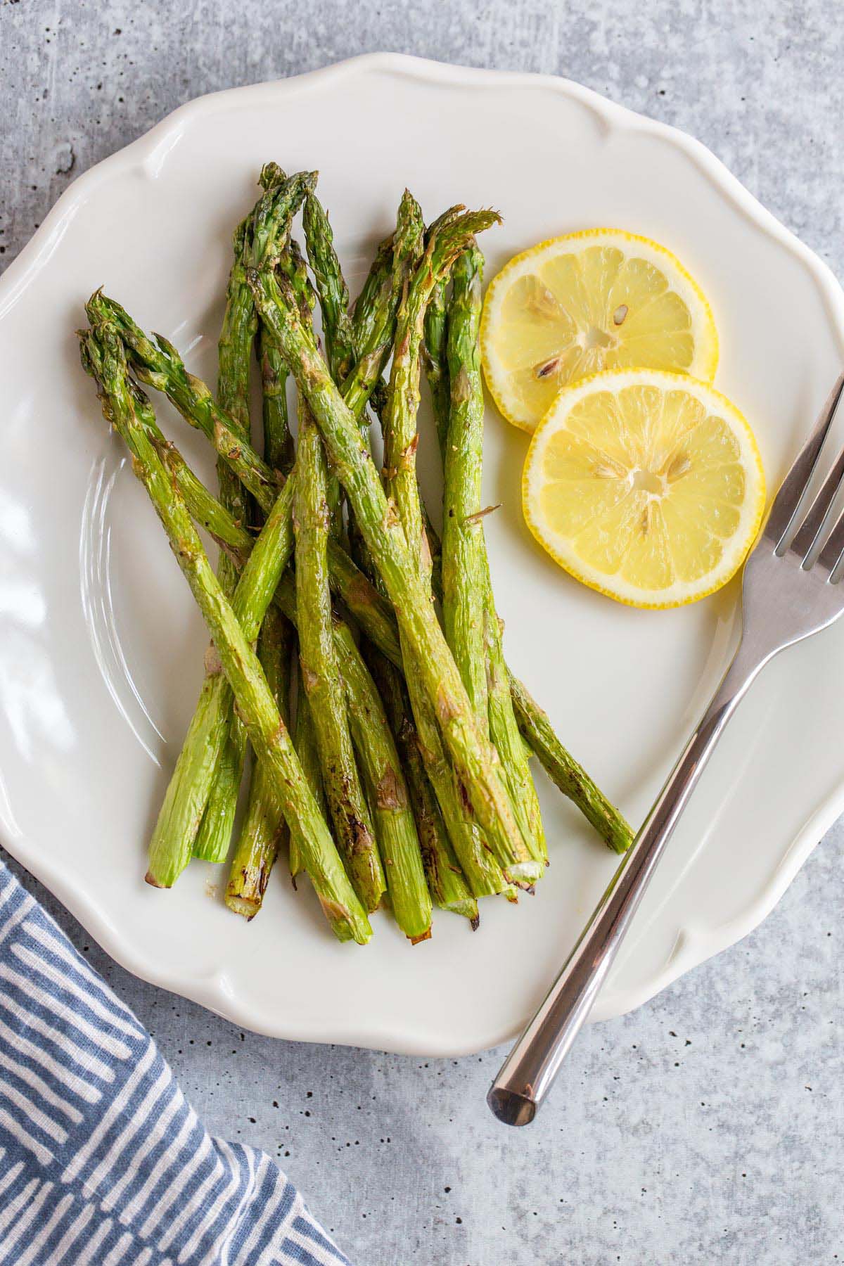 Asparagus on a plate with lemon slices.