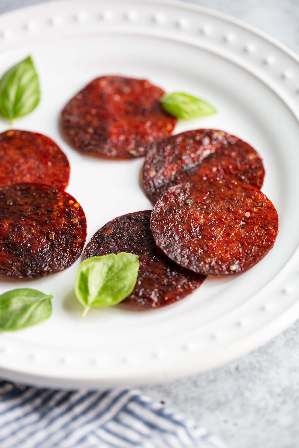 Salami chips on a plate with basil