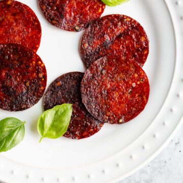 Salami chips on a plate with basil