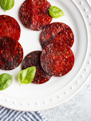 Salami chips on a plate with basil