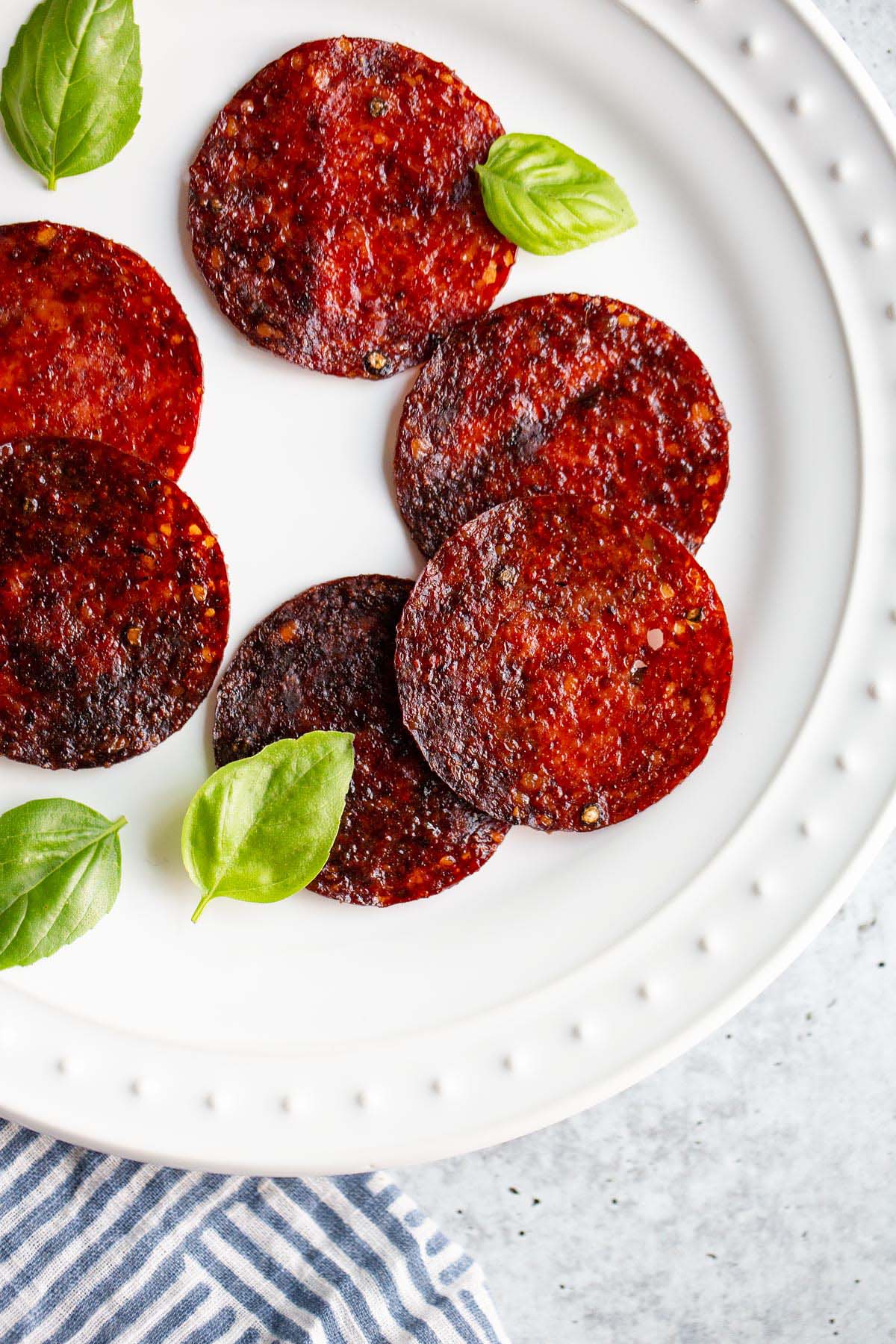 Salami chips on a plate with basil