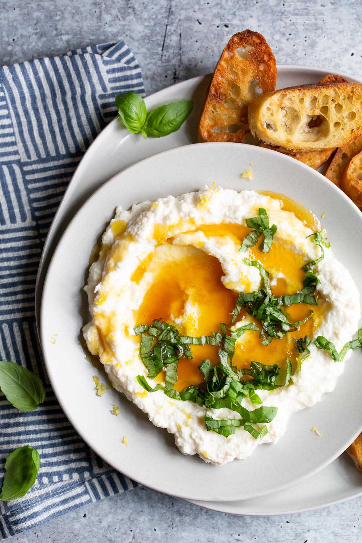 ricotta in a bowl topped with honey and lemon zest