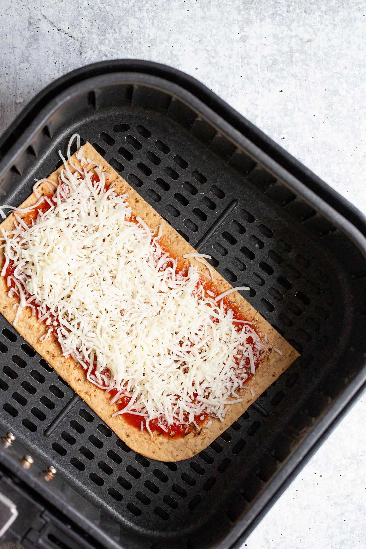 Uncooked air fryer flatbread pizza.