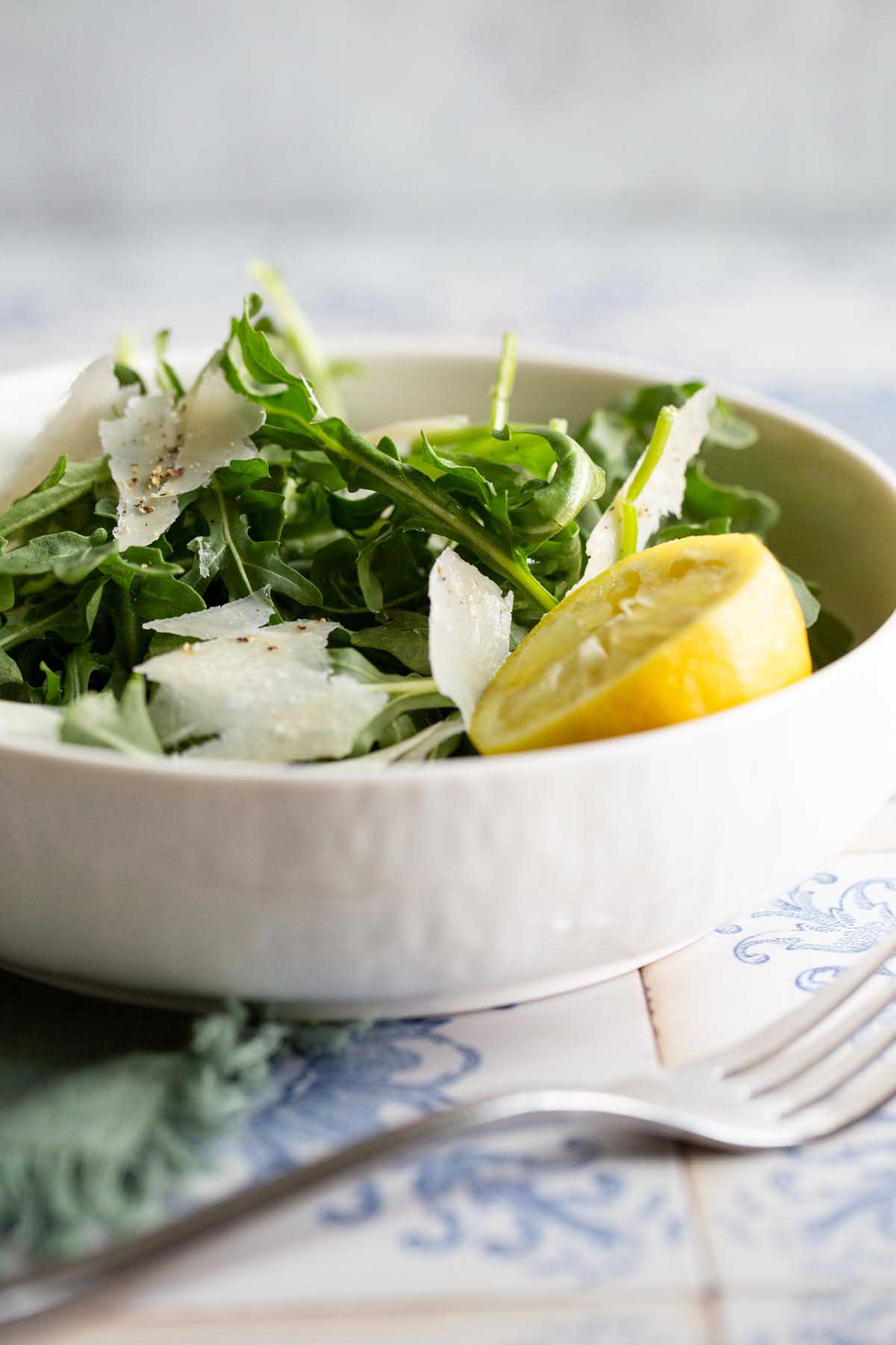 arugula salad with lemon in a white bowl