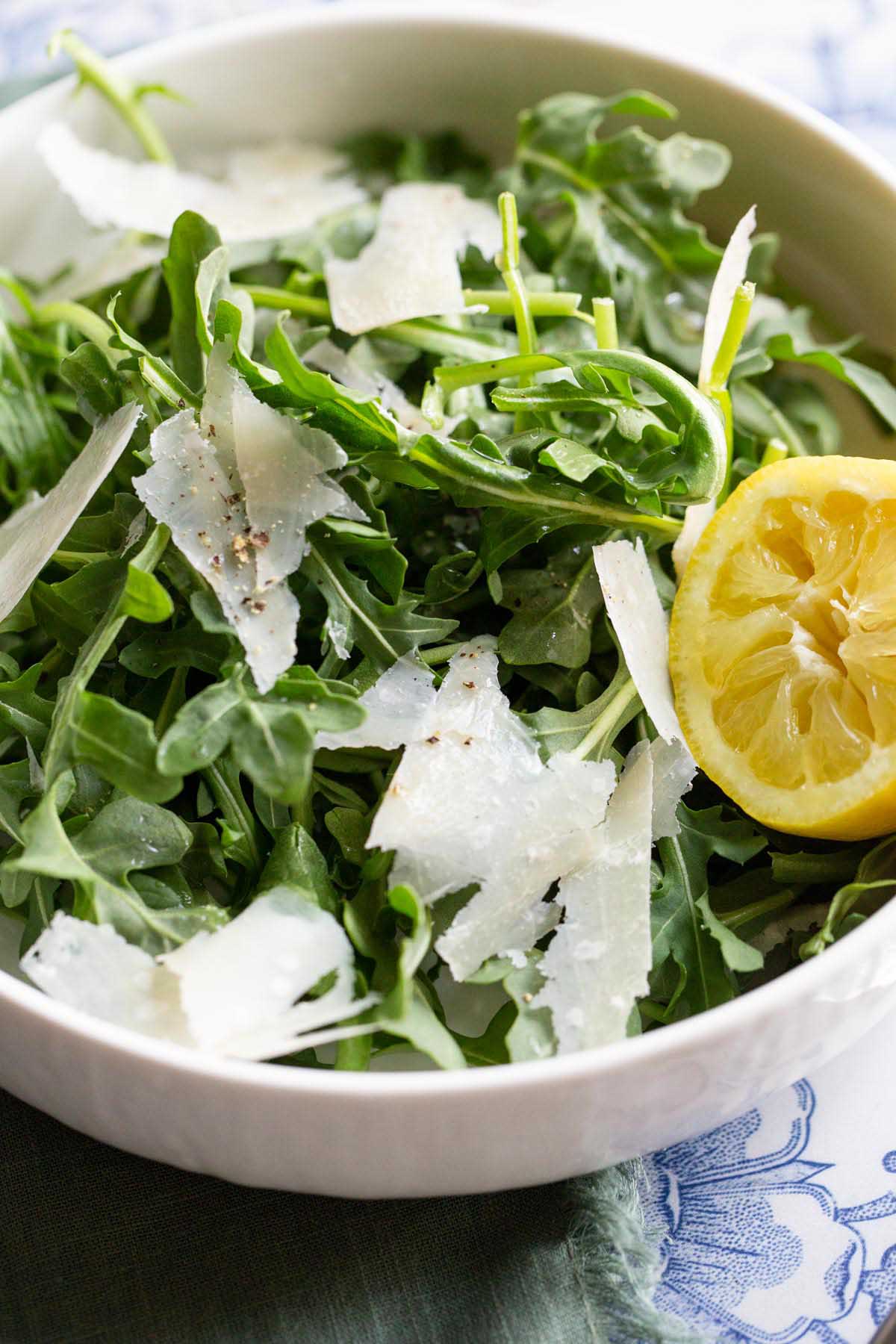 arugula salad with lemon in a white bowl