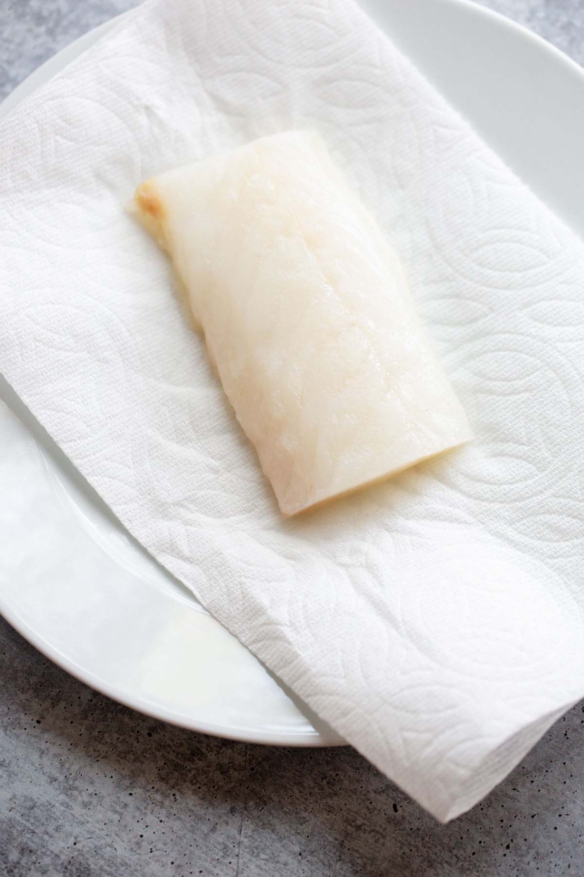 Raw cod on a paper towel.