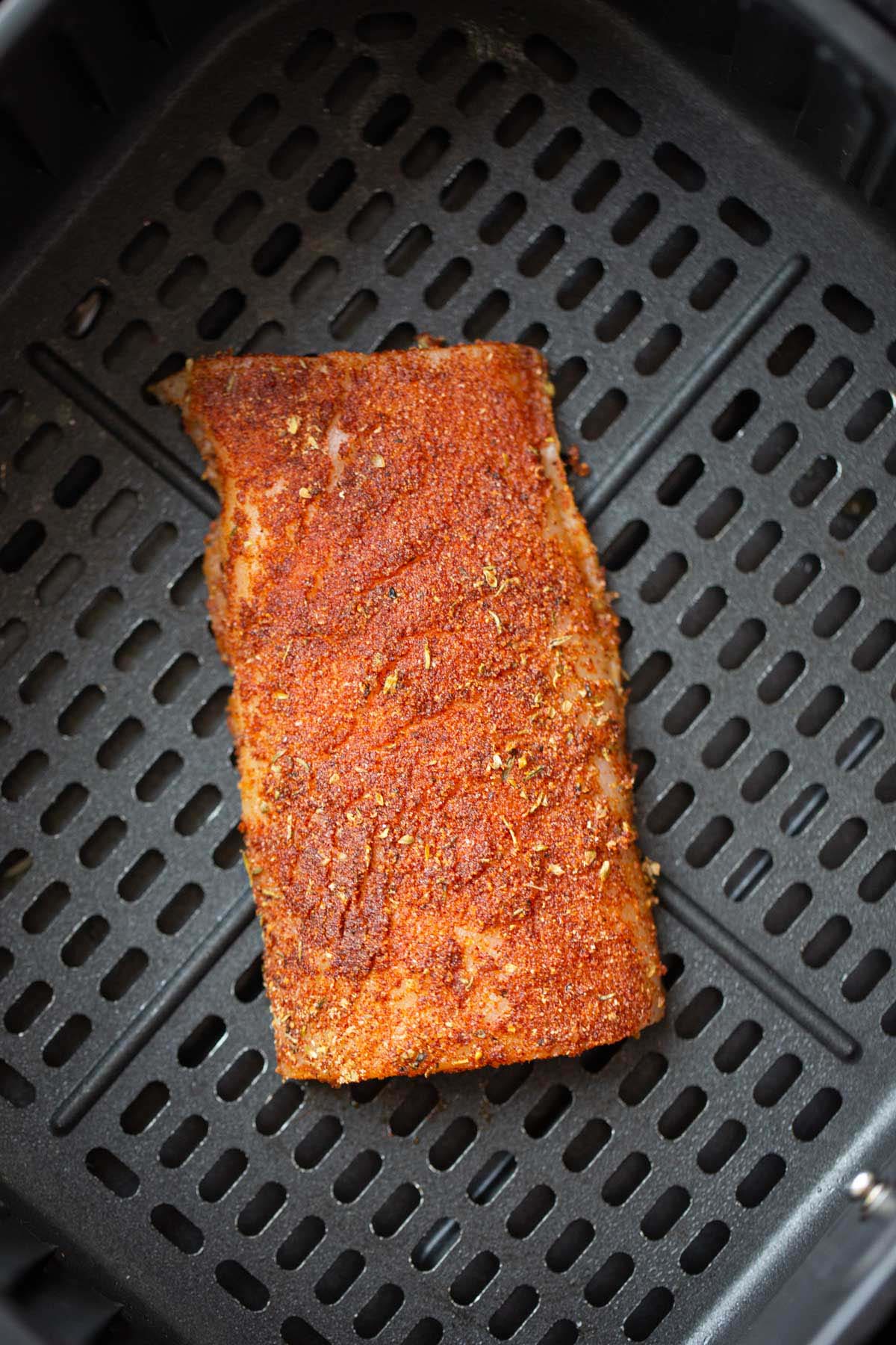 Cod in air fryer basket.