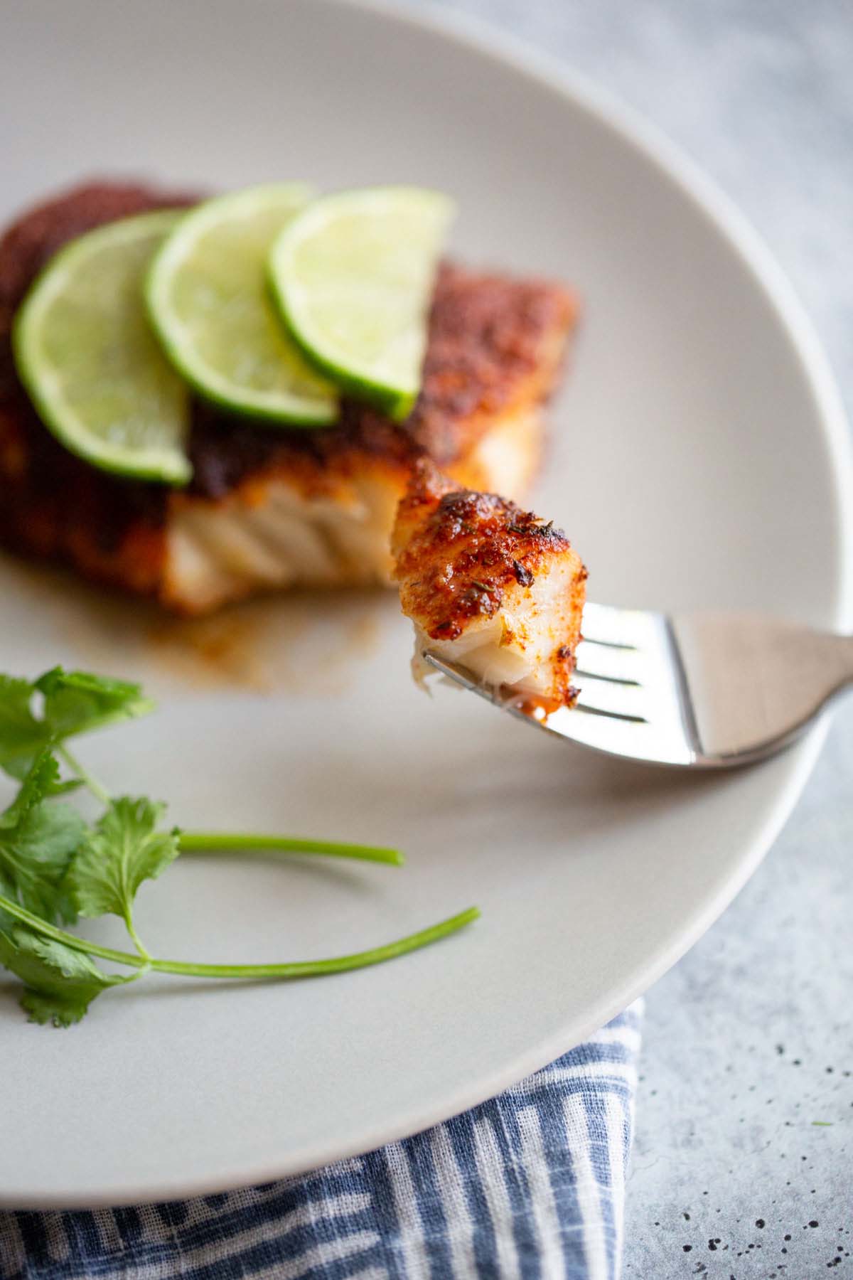 Blackened cod with lime slices.