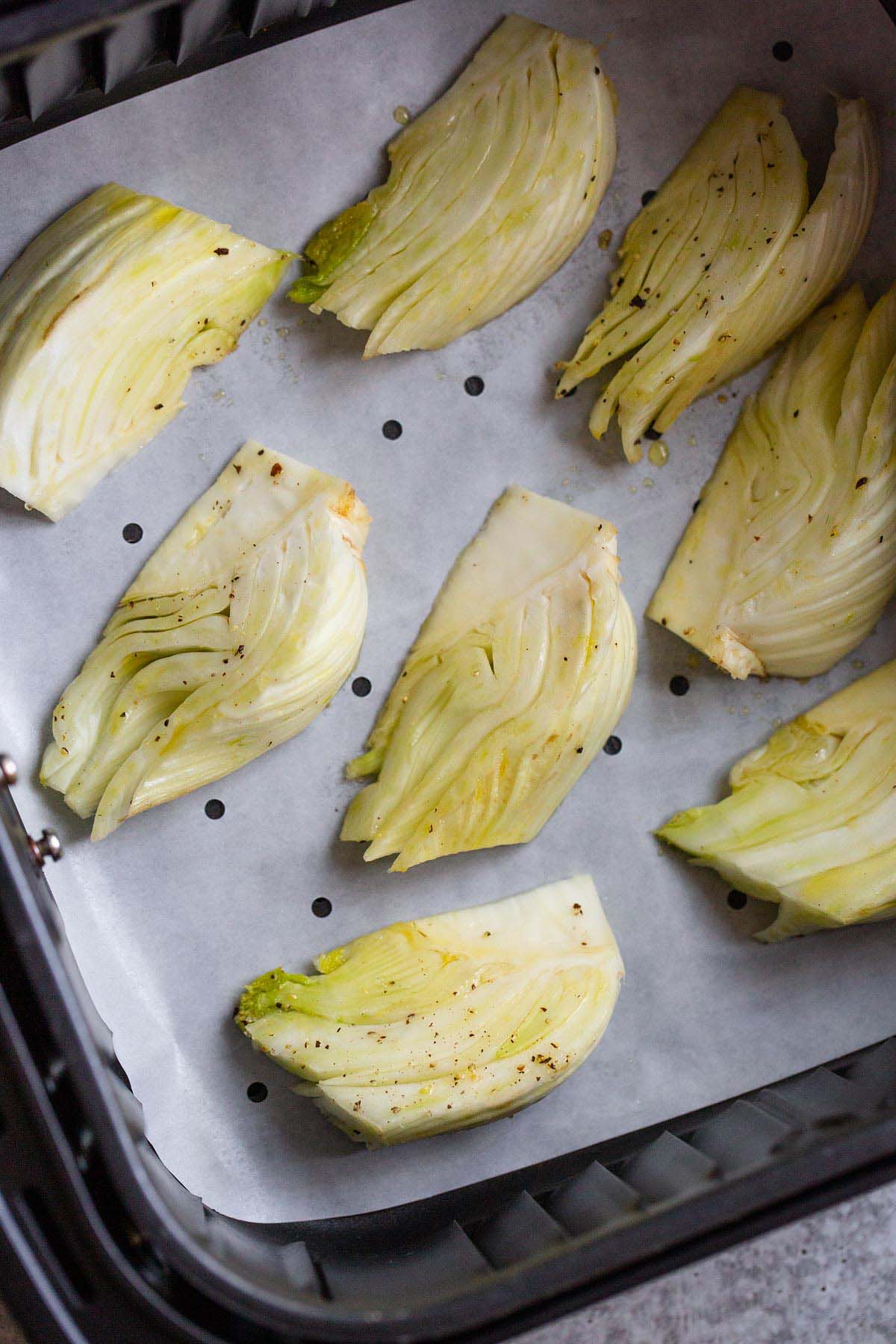 Fennel wedges in air fryer basket.