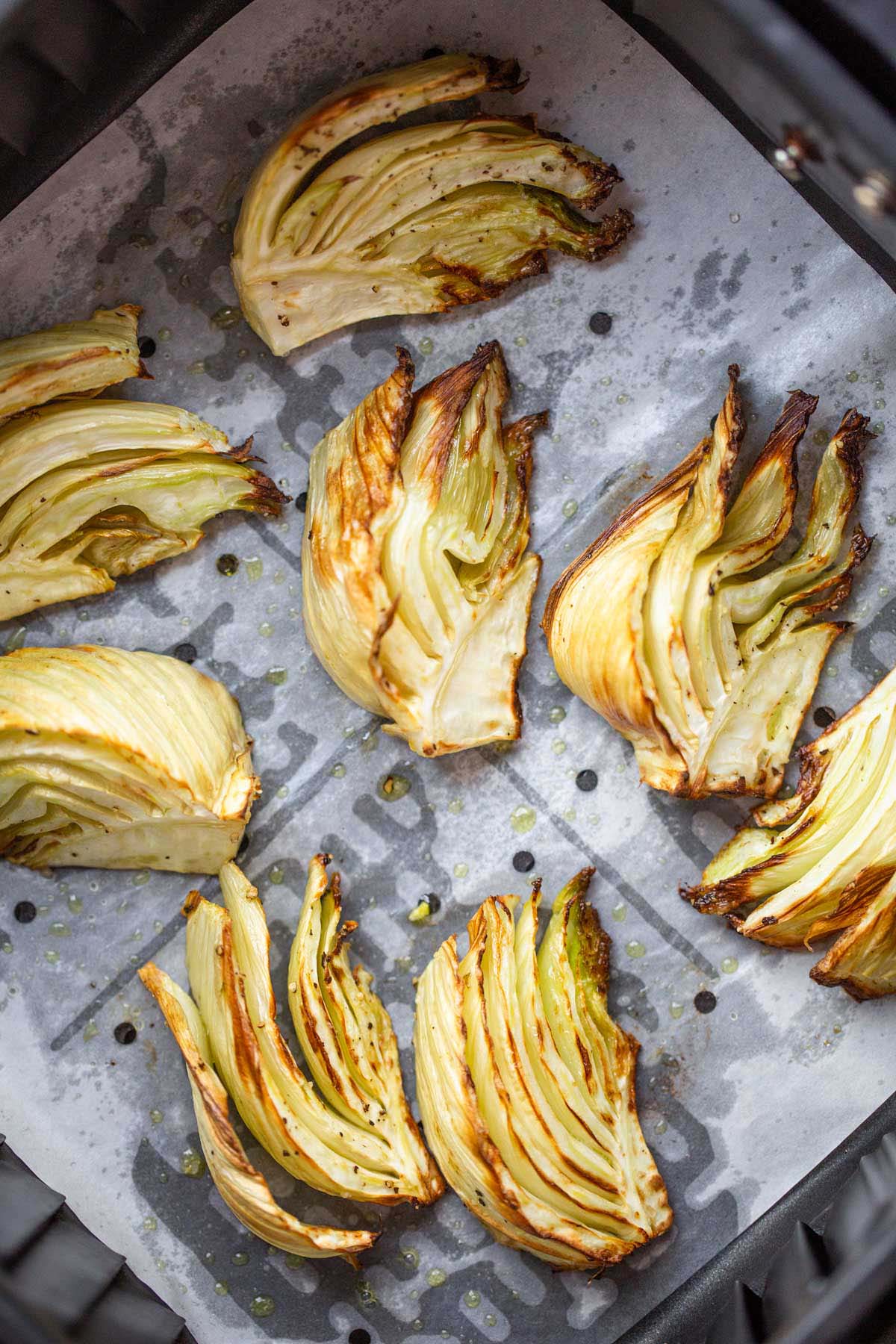 Roasted fennel wedges in air fryer basket.