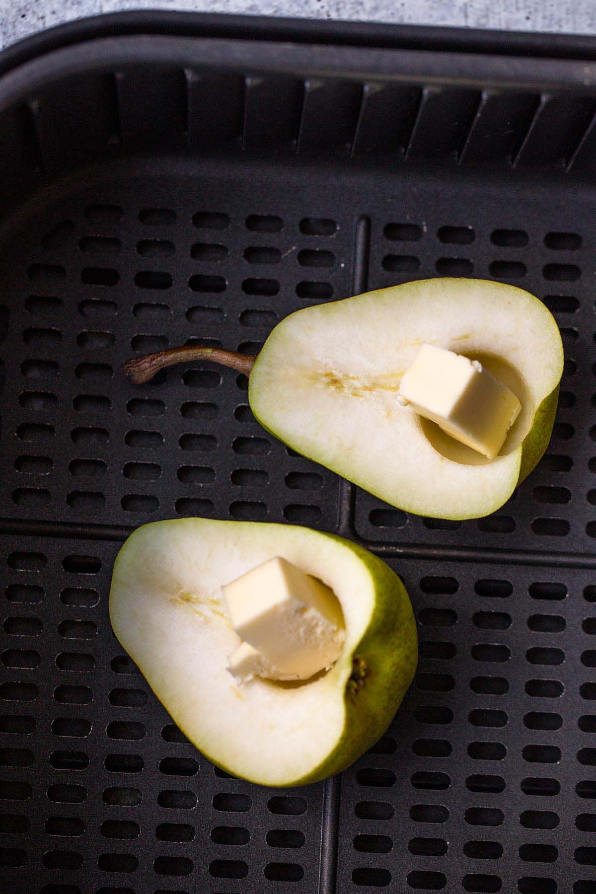 Pears with butter in air fryer basket.