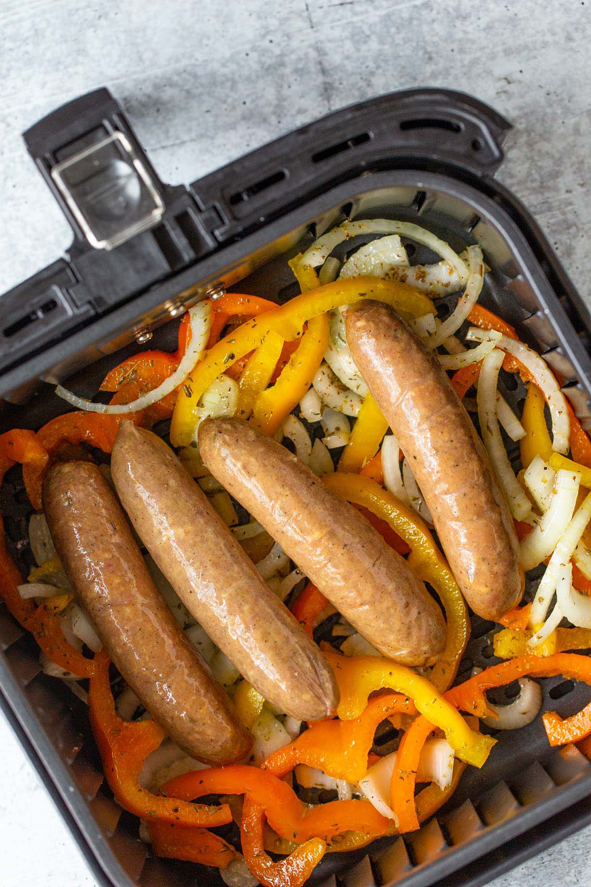 Sausage and peppers in air fryer basket.