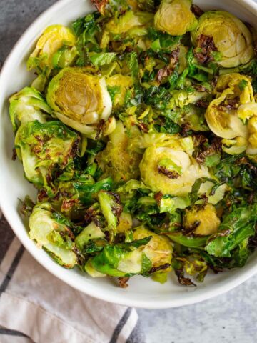 air fried brussels sprouts in a white bowl.