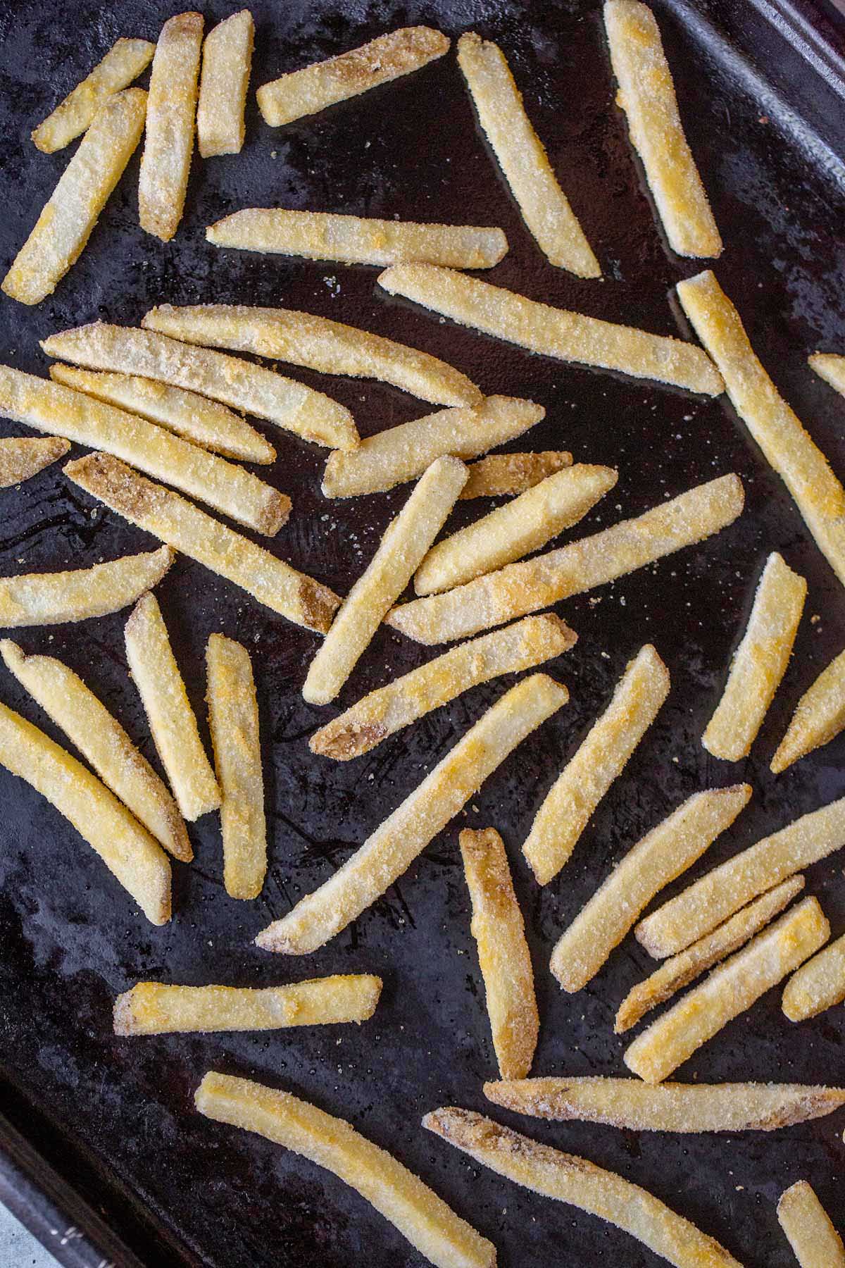 Baked french fries on a sheet pan.