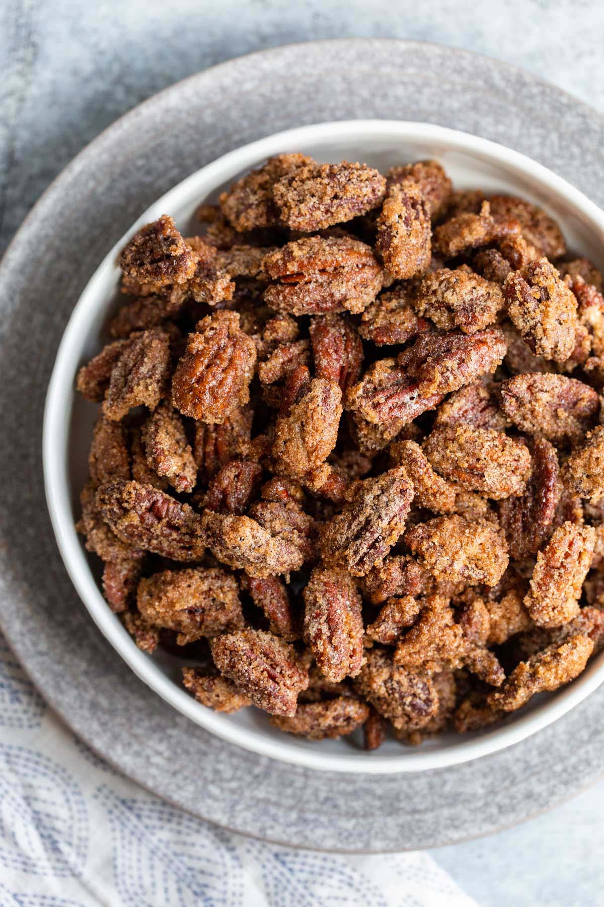 Candied pecans in a white bowl.