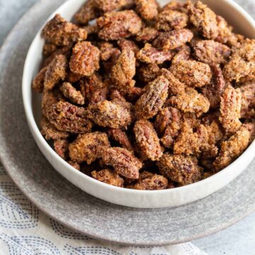 Candied pecans in a white bowl.