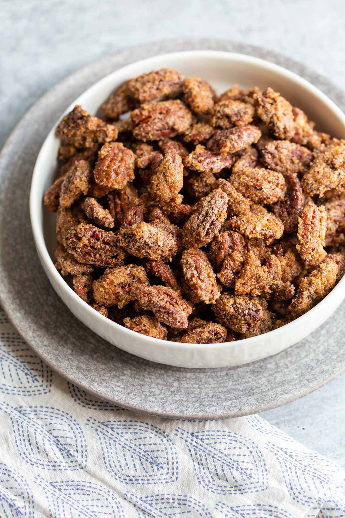 Candied pecans in a white bowl.