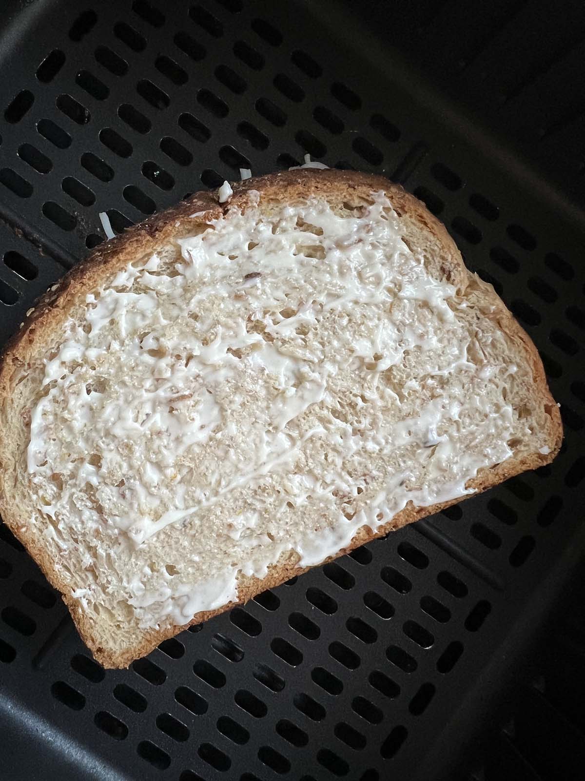 Uncooked grilled cheese in air fryer basket.