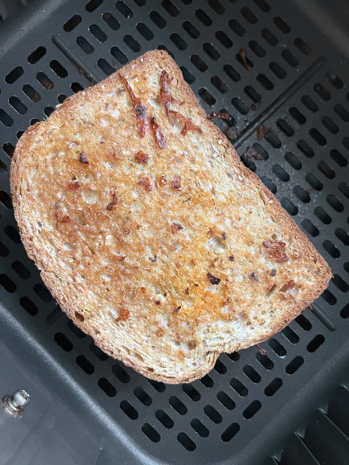 Grilled cheese in air fryer basket.
