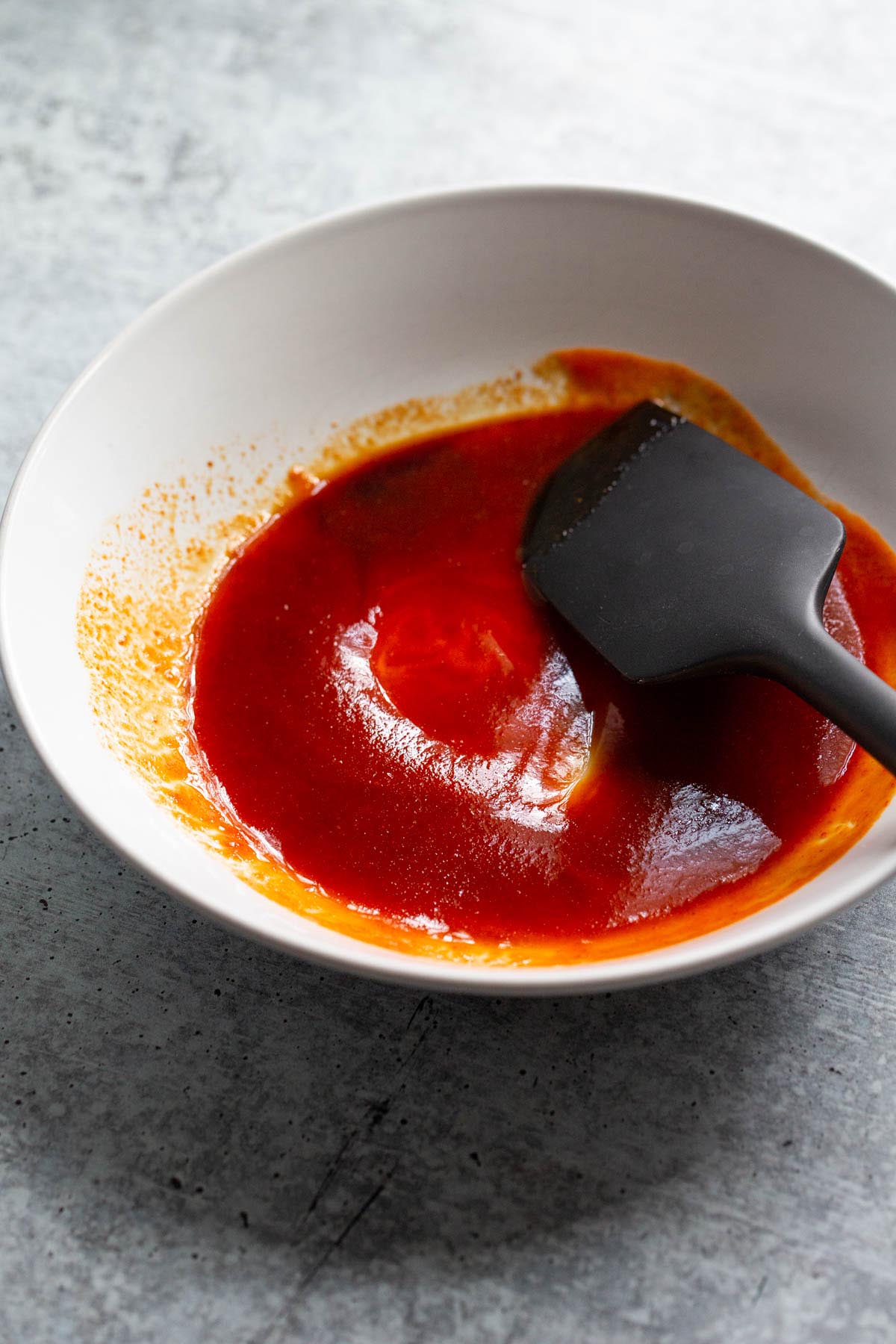 Mixing together honey sriracha sauce.