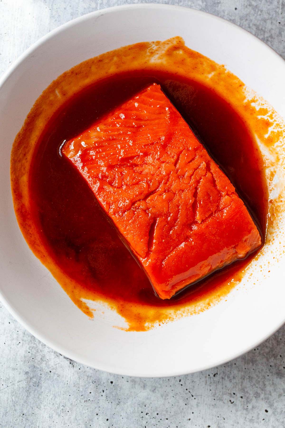 Salmon marinating in sriracha sauce.